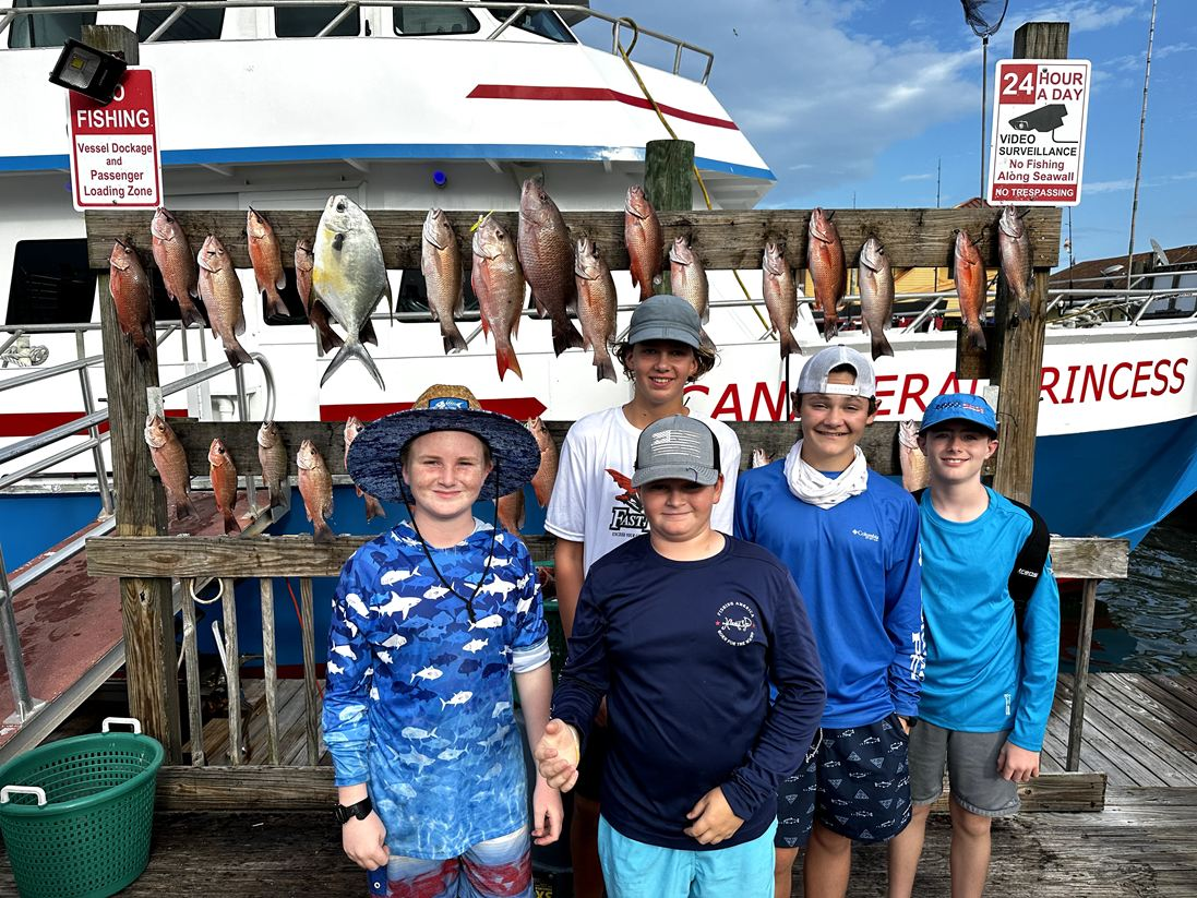 Family enjoying deep sea fishing adventure near Orlando, kids reeling in fish together
